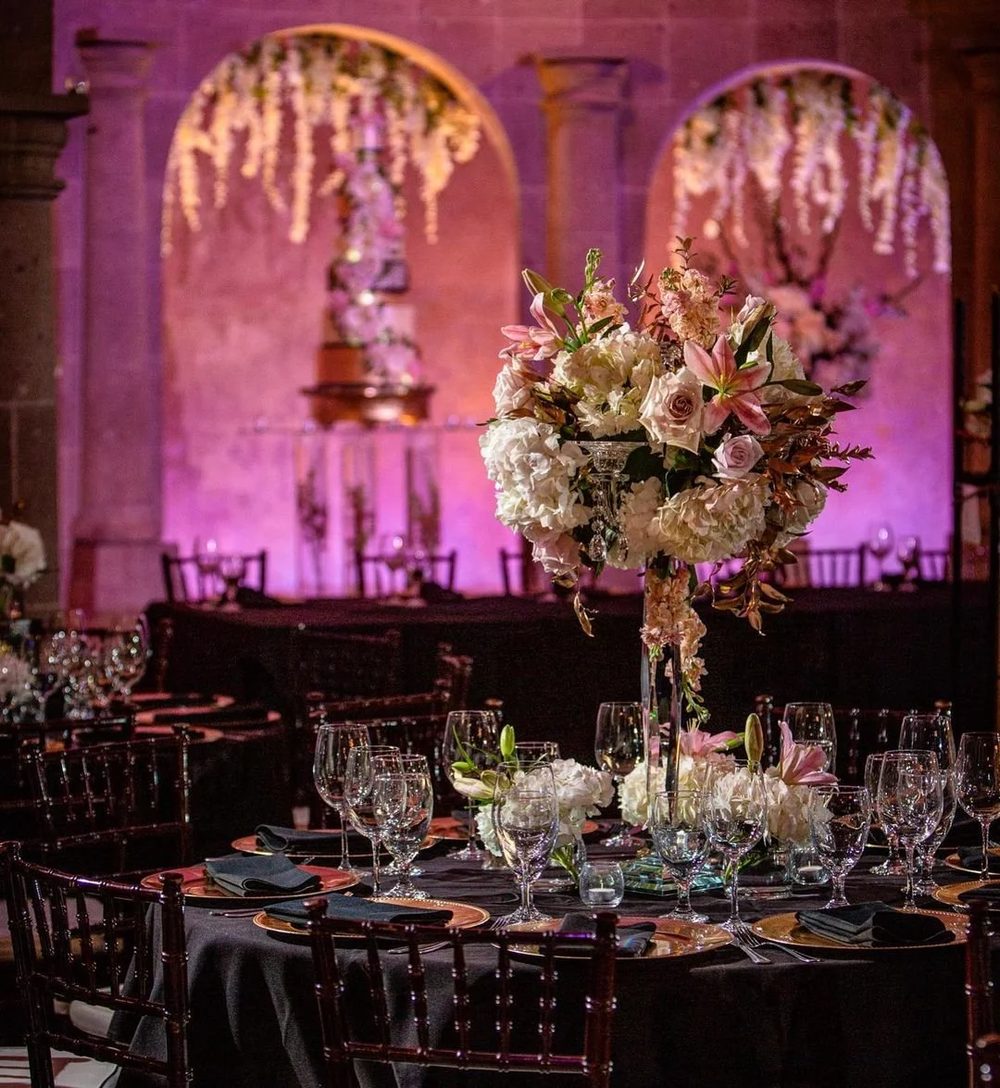 Tall white and pink floral centerpiece on a reception table at a quinceañera at The Bell Tower on 34th, Houston, TX.
